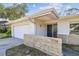 Close-up of the home's front exterior featuring an attached garage and well-maintained landscaping at 1714 Cypress Ave, Belleair, FL 33756