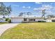 Well-kept single-story home with a manicured lawn and a convenient attached garage at 1714 Cypress Ave, Belleair, FL 33756