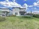 Spacious fenced-in backyard featuring a trampoline, lush lawn and a covered patio with glass sliding doors at 17737 Everlong Dr, Land O Lakes, FL 34638