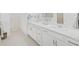 Bright bathroom featuring a double sink vanity with white cabinets, elegant fixtures, and a mirror at 17737 Everlong Dr, Land O Lakes, FL 34638