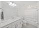 Bright bathroom featuring a single sink vanity with white cabinets and a shower with a striped curtain at 17737 Everlong Dr, Land O Lakes, FL 34638