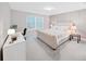 Cozy bedroom featuring neutral walls, a comfortable bed, stylish furniture, and modern accents at 17737 Everlong Dr, Land O Lakes, FL 34638