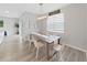Bright dining room with wood floors, a rustic table, modern lighting, and plenty of natural light at 17737 Everlong Dr, Land O Lakes, FL 34638