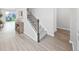 Bright foyer featuring wood-look floors, iron-spindled staircase, console table, and natural light streaming through a sliding glass door at 17737 Everlong Dr, Land O Lakes, FL 34638