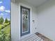 Close-up of the front entrance, showcasing a blue door with glass window, wreath, brick steps, and a striped welcome mat at 17737 Everlong Dr, Land O Lakes, FL 34638