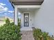 Inviting front entrance features a stylish blue door with glass panel, brick steps, and tasteful landscaping, including a door wreath at 17737 Everlong Dr, Land O Lakes, FL 34638