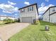 Charming two-story home featuring a gray two-car garage, complemented by a brick paved driveway and manicured front yard at 17737 Everlong Dr, Land O Lakes, FL 34638