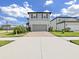 Charming two-story home featuring a gray two-car garage, complemented by a concrete driveway and manicured front yard at 17737 Everlong Dr, Land O Lakes, FL 34638