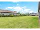 Large, flat backyard with lush green grass, bordered by a sleek black fence and mature landscaping at 17804 Brewster Grn, Lutz, FL 33559