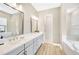 Elegant bathroom featuring dual sinks, quartz countertops, and a tiled shower at 17804 Brewster Grn, Lutz, FL 33559