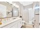 Modern bathroom with dual sinks, a large mirror, a white vanity, and a shower-tub combination at 17804 Brewster Grn, Lutz, FL 33559