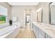 Luxurious bathroom with a soaking tub, double vanity, and a view to the outdoors at 17804 Brewster Grn, Lutz, FL 33559