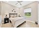 Bright bedroom features wood-look floors, a ceiling fan, and a window with a view of the neighborhood at 17804 Brewster Grn, Lutz, FL 33559