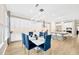 Dining room with modern table, blue chairs, wood floors, and a view of the kitchen at 17804 Brewster Grn, Lutz, FL 33559