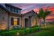 Exterior view of a home with a stone facade, green landscaping, and warm exterior lighting at 17804 Brewster Grn, Lutz, FL 33559