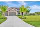 Charming home featuring a 3-car garage, stone accents, and a well-manicured lawn with mature palm trees at 17804 Brewster Grn, Lutz, FL 33559