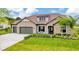Charming single-story home features a stone facade, well-manicured lawn, and a two-car garage at 17804 Brewster Grn, Lutz, FL 33559