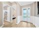 Bright foyer with white wainscoting, wood-look tile flooring, and a frosted glass front door at 17804 Brewster Grn, Lutz, FL 33559