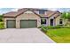 A spacious three-car garage with stone accents and lush landscaping at 17804 Brewster Grn, Lutz, FL 33559