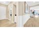 Bright hallway featuring wood-look tile floors, neutral walls with wainscoting, and an open doorway to the living area at 17804 Brewster Grn, Lutz, FL 33559