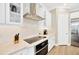 Modern kitchen with white cabinets, stainless steel range hood, built-in oven, and stylish subway tile backsplash at 17804 Brewster Grn, Lutz, FL 33559