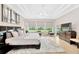 Bright main bedroom with a king bed, plush rug, and a wall of windows overlooking the backyard at 17804 Brewster Grn, Lutz, FL 33559