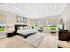 Spacious main bedroom with tray ceilings, large windows offering scenic views, and a cozy seating area at 17804 Brewster Grn, Lutz, FL 33559