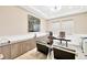 A home office with neutral walls, modern decor, two guest chairs, and two windows with blinds at 17804 Brewster Grn, Lutz, FL 33559