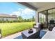Relaxing covered patio featuring modern furniture, a stylish rug, and serene views of the expansive backyard at 17804 Brewster Grn, Lutz, FL 33559