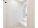 Modern walk-in shower with floor-to-ceiling tile and a built-in bench seat at 17804 Brewster Grn, Lutz, FL 33559