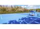 Community tennis court surrounded by trees and fencing at 17804 Brewster Grn, Lutz, FL 33559