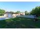 Fenced backyard showcasing a detached garage and mature trees at 18121 Geraci Rd, Lutz, FL 33548