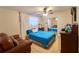 Cozy bedroom with a ceiling fan, bed, dresser, and a window with curtains at 18121 Geraci Rd, Lutz, FL 33548