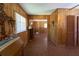 A long hall with wood paneling, tiled floors, and views through doorways to other rooms of the home at 18121 Geraci Rd, Lutz, FL 33548