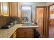This kitchen features granite counters and a sink with views to the dining room and hallway at 18121 Geraci Rd, Lutz, FL 33548