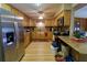 Well-lit kitchen featuring wood cabinets, stone countertops, stainless steel appliances, and wood-look floors at 18121 Geraci Rd, Lutz, FL 33548