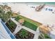 Sandy beach with clear water, a pier, and palm trees, plus manicured grounds and tiki umbrellas at 18500 Gulf Blvd # 406, Indian Shores, FL 33785