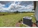 Backyard with a lush lawn, view of the pond, and the home's AC unit at 190 Rain Berry Ave, Ruskin, FL 33570
