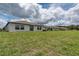 Wide backyard view with a lush lawn and back exterior view of several homes at 190 Rain Berry Ave, Ruskin, FL 33570