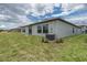 Backyard with a lush lawn and back exterior view of the home featuring sliding glass doors at 190 Rain Berry Ave, Ruskin, FL 33570