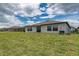 Wide backyard view with a lush lawn and back exterior view of the home at 190 Rain Berry Ave, Ruskin, FL 33570