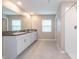 Bright bathroom featuring double sinks, granite countertops, and a walk-in shower at 190 Rain Berry Ave, Ruskin, FL 33570