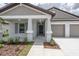 Close-up of front entrance with gray shutters, white columns, covered entrance and 2-car garage at 190 Rain Berry Ave, Ruskin, FL 33570