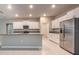 Well-lit kitchen boasts stainless steel appliances, white cabinets, granite counters and pantry at 190 Rain Berry Ave, Ruskin, FL 33570