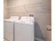 Bright laundry room featuring a new washer and dryer with an above shelf for extra storage at 190 Rain Berry Ave, Ruskin, FL 33570