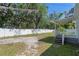 Fenced backyard features a covered porch, gravel, and mature trees, offering privacy at 19496 Wildwood Dr, Brooksville, FL 34601
