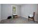 Empty bedroom with light gray carpet, a window, and a chair presents a versatile space at 19496 Wildwood Dr, Brooksville, FL 34601