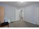 Bedroom featuring gray carpet and a doorway offers a peek into another room at 19496 Wildwood Dr, Brooksville, FL 34601