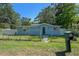 Charming single-story home with a fenced yard, lush trees and inviting curb appeal at 19496 Wildwood Dr, Brooksville, FL 34601