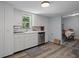 Bright kitchen features white cabinetry, stainless steel dishwasher, and wood-look flooring at 19496 Wildwood Dr, Brooksville, FL 34601
